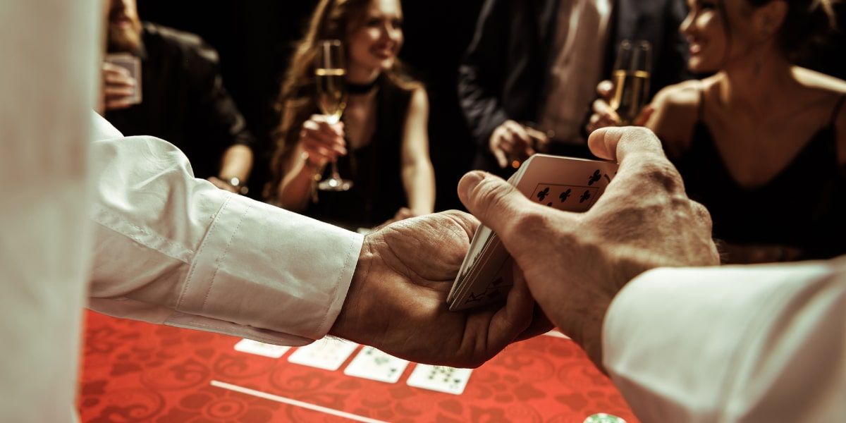 casino dealer who is shuffling cards, casino players sitting at his casino table